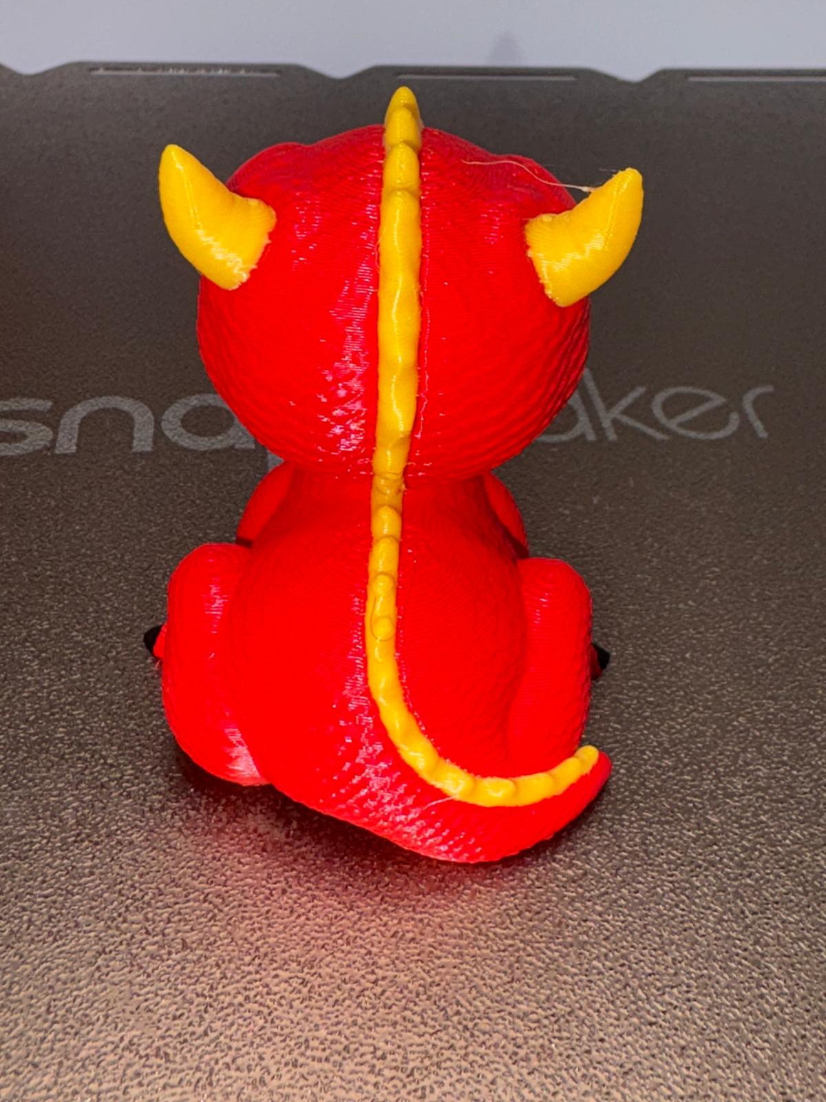 Rear view showing the verified yellow spine, horns, tail, and selected rear seam
